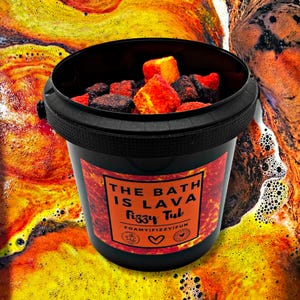 May include: A black bucket filled with red and black bath bombs. The bucket has a label that reads "THE BATH IS LAVA Fizzy Tub" with the words "FOAMYFIZZYFUN" below. The background is a colourful, bubbly, lava-like design.