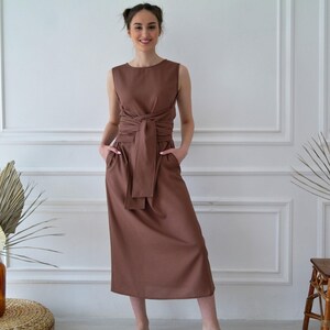 Women's kimono linen dress showing side pockets, waist tie, and relaxed fit