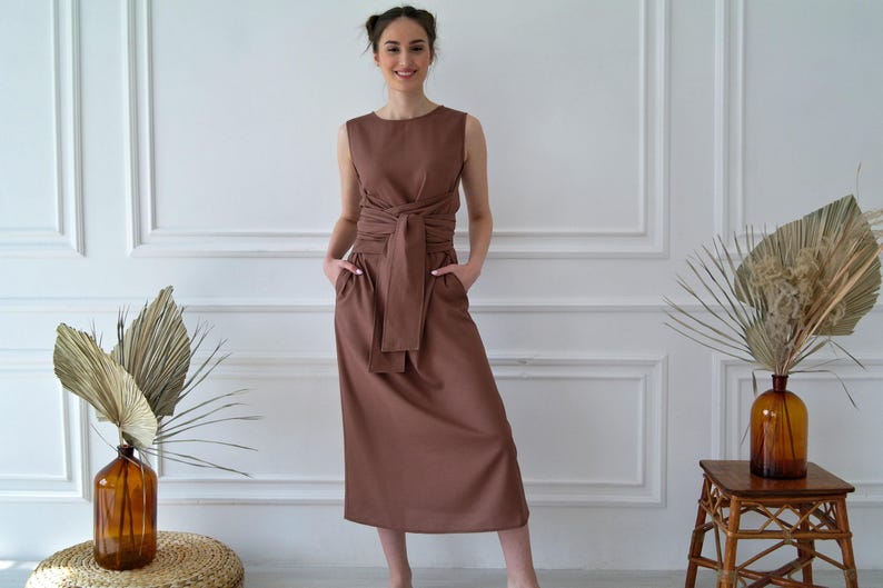 Women's kimono linen dress showing side pockets, waist tie, and relaxed fit