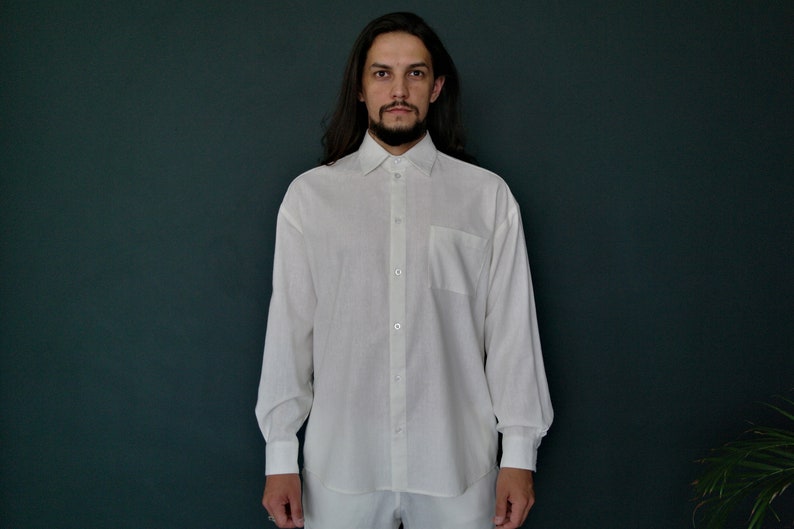 May include: A white long-sleeved button-down shirt with a pocket on the left chest.