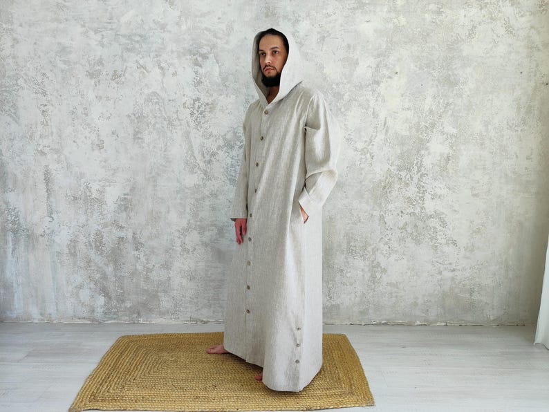 Men's Undyed Hooded Linen Kaftan with Button Front Side Slits and Deep Pockets, side view showing an undyed, hooded linen kaftan showing the relaxed fit and side pockets.