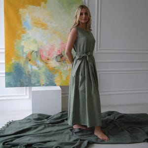 Women's pleated maxi linen dress showing crew neck, waist tie, and pleated skirt