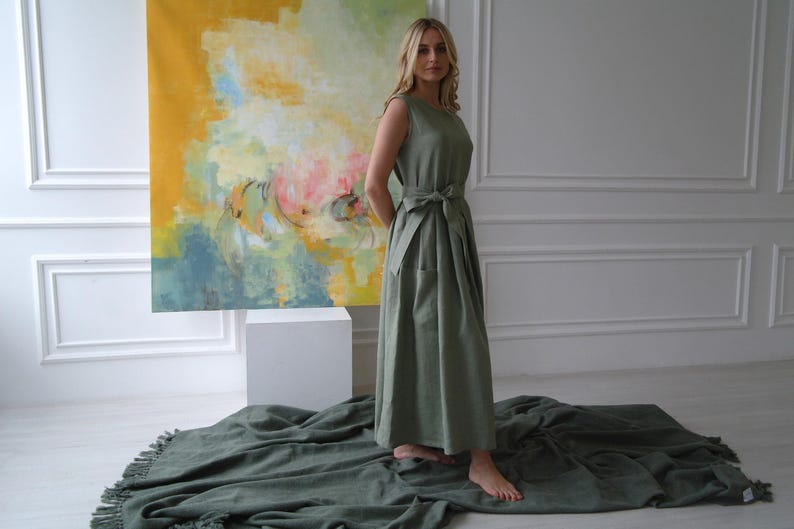Women's pleated maxi linen dress showing crew neck, waist tie, and pleated skirt