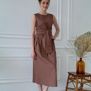 Women's kimono linen dress showing waist tie, side pockets, and relaxed silhouette