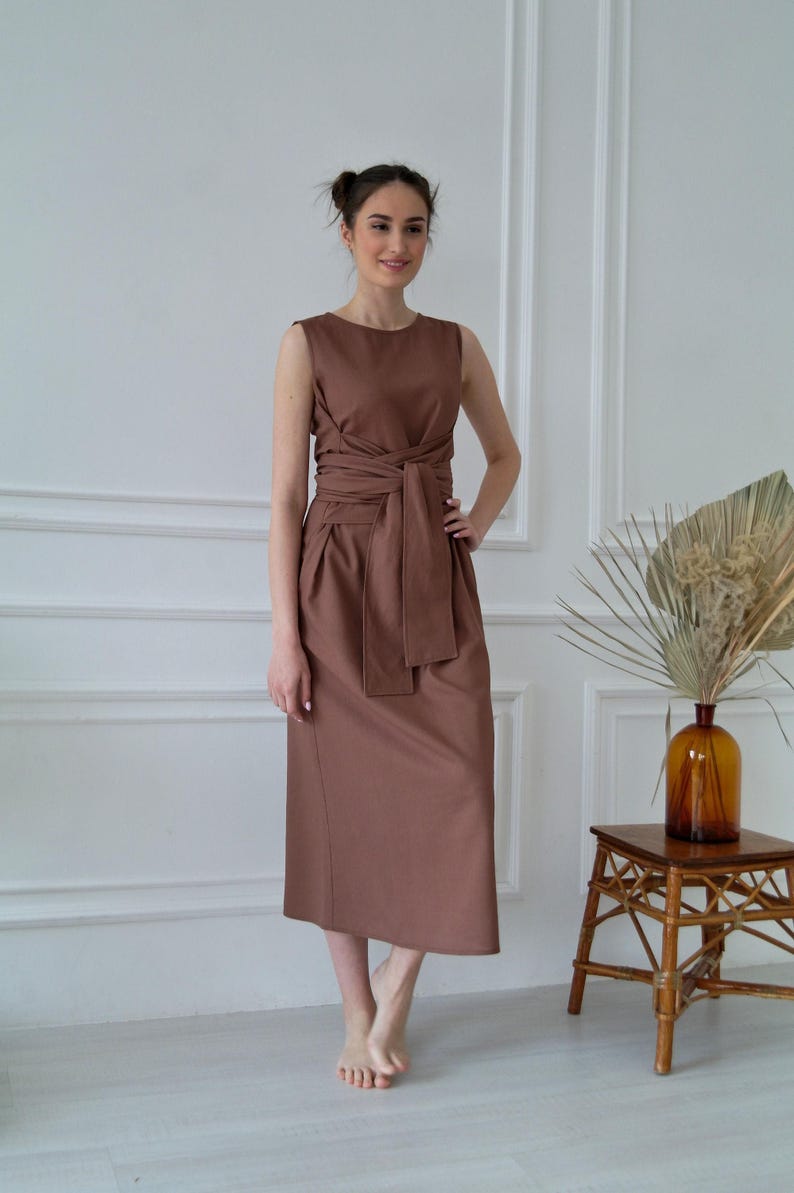 Women's kimono linen dress showing waist tie, side pockets, and relaxed silhouette