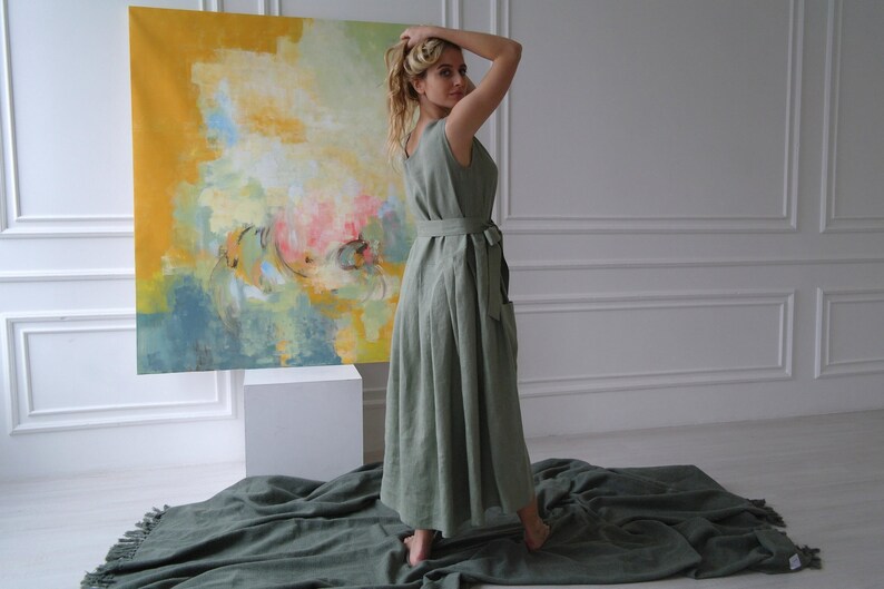 Women's pleated maxi linen dress side view showing waist tie and pleated skirt