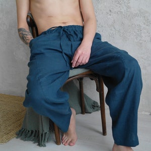 Pode incluir: Uma cal&ccedil;a de linho azul-turquesa com cintura de cord&atilde;o. A cal&ccedil;a &eacute; larga e tem um visual relaxado e confort&aacute;vel.