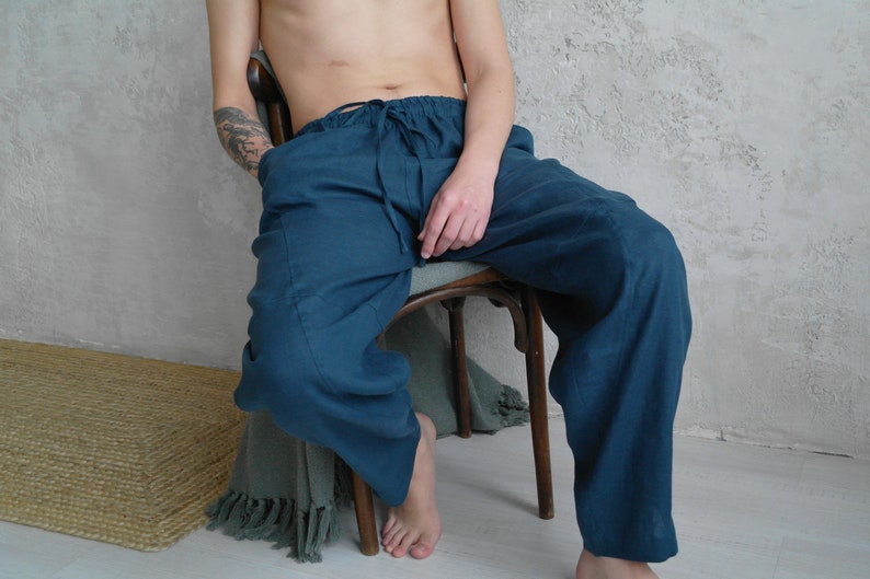 Pode incluir: Uma cal&ccedil;a de linho azul-turquesa com cintura de cord&atilde;o. A cal&ccedil;a &eacute; larga e tem um visual relaxado e confort&aacute;vel.