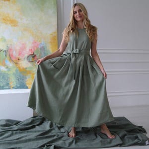 Women's pleated maxi linen dress showing waist tie, pleated skirt, and slightly dropped waist