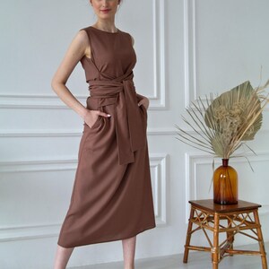 Women's kimono linen dress showing waist tie, side pockets, and relaxed fit