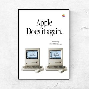 May include: A framed poster featuring the text "Apple Does it again." and two vintage Macintosh 512K computers. The poster includes the Apple logo and the phrase "Introducing the Macintosh 512K". The computer screens display the words "hello" and "hello again."
