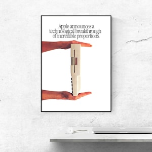 May include: A vintage advertisement poster featuring a beige computer keyboard held between two hands. The text at the top reads: Apple announces a technological breakthrough of incredible proportions. The poster is framed in a thin black border.