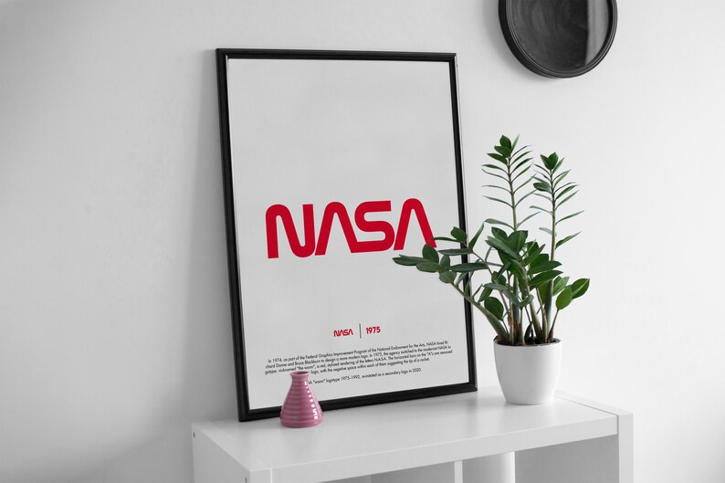 May include: A black framed poster with the NASA logo in red. The poster has the text "NASA | 1975" and a description of the logo's history.