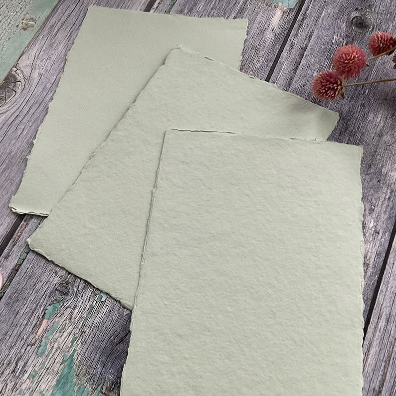 May include: Three sheets of light green textured paper with deckled edges.