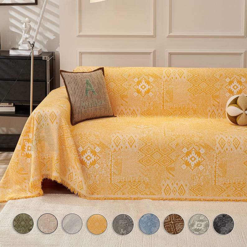 May include: A yellow sofa throw with a geometric pattern and fringed edges. A decorative cushion with a brown border and a patterned design rests on the sofa. The image also shows a selection of colour swatches.
