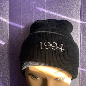 May include: Black beanie with a white embroidered '1994' on the front.