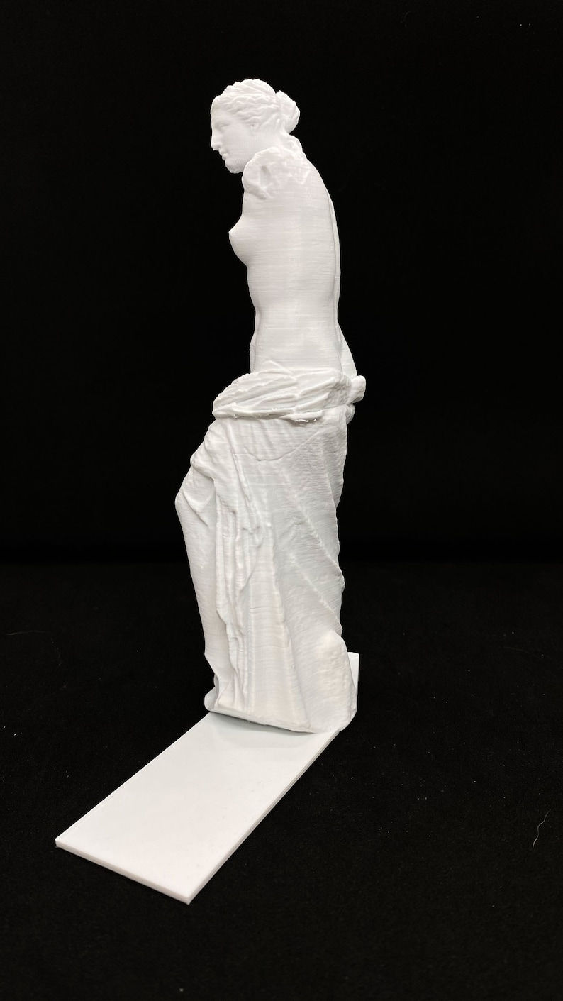 May include: A white 3D printed statue of the Venus de Milo, a famous Greek sculpture, standing on a white base.