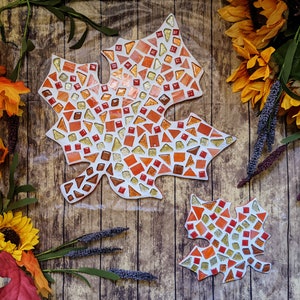 May include: Two mosaic leaf-shaped wall decorations in shades of orange, red, and gold. The larger leaf is about 12 inches wide and the smaller leaf is about 6 inches wide.