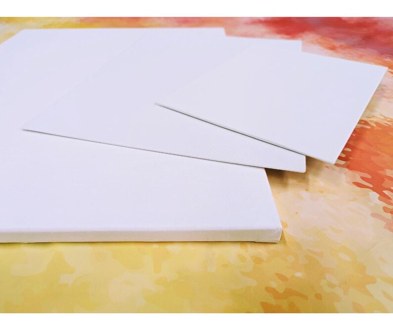 May include: Four white canvases of different sizes stacked on top of each other. The canvases are blank and ready for painting.