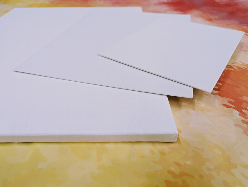 May include: Three white canvas boards of different sizes stacked on top of each other. The boards are blank and ready for painting.
