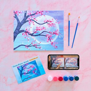 May include: A paint-by-numbers kit featuring a cherry blossom branch with a full moon in the background. The kit includes a canvas, paint tubes, brushes, and a reference image. The kit is titled "Cherry Blossom Branch Painting Kit".