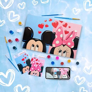 May include: Two paint-by-number canvases featuring Mickey Mouse and Minnie Mouse with hearts and the text "Wishing You Love" and "Welcome to Love". The canvases are surrounded by paint pots, brushes, and a video tutorial.