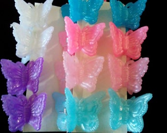 May include: A set of 12 butterfly hair clips in various pastel colors, including pink, blue, purple, and white. The clips are made of plastic and have a shiny finish.