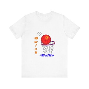 May include: White t-shirt with a basketball graphic. The design shows a red basketball going through a purple hoop, with the words "Swish Ballin" in orange and blue.
