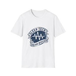 Könnte beinhalten: Weißes T-Shirt mit marineblauem Aufdruck. Der Aufdruck zeigt die Schriftzüge "SLEEP TECH" und "DREAM WATCHER" um ein stilisiertes Herzschlag-Design. Das Shirt hat einen Rundhalsausschnitt und kurze Ärmel.