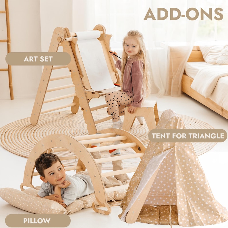 May include: A wooden art set with a child using it. The set includes an easel with a paper roll, a climbing arch, and a tent. The text "ADD-ONS", "ART SET", "TENT FOR TRIANGLE", and "PILLOW" are visible.