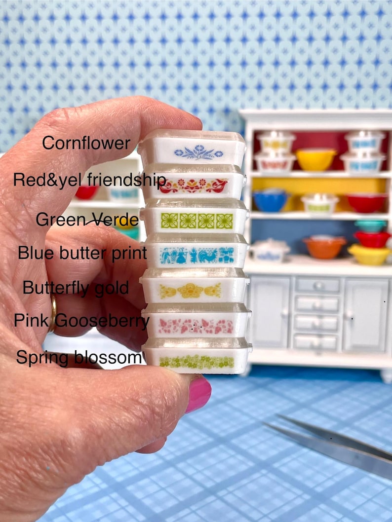 May include: A stack of miniature Pyrex-style dishes in various patterns and colors, including blue, red, green, and yellow. The dishes are held in a hand, with a miniature cabinet in the background. The text on the image lists the names of the patterns.