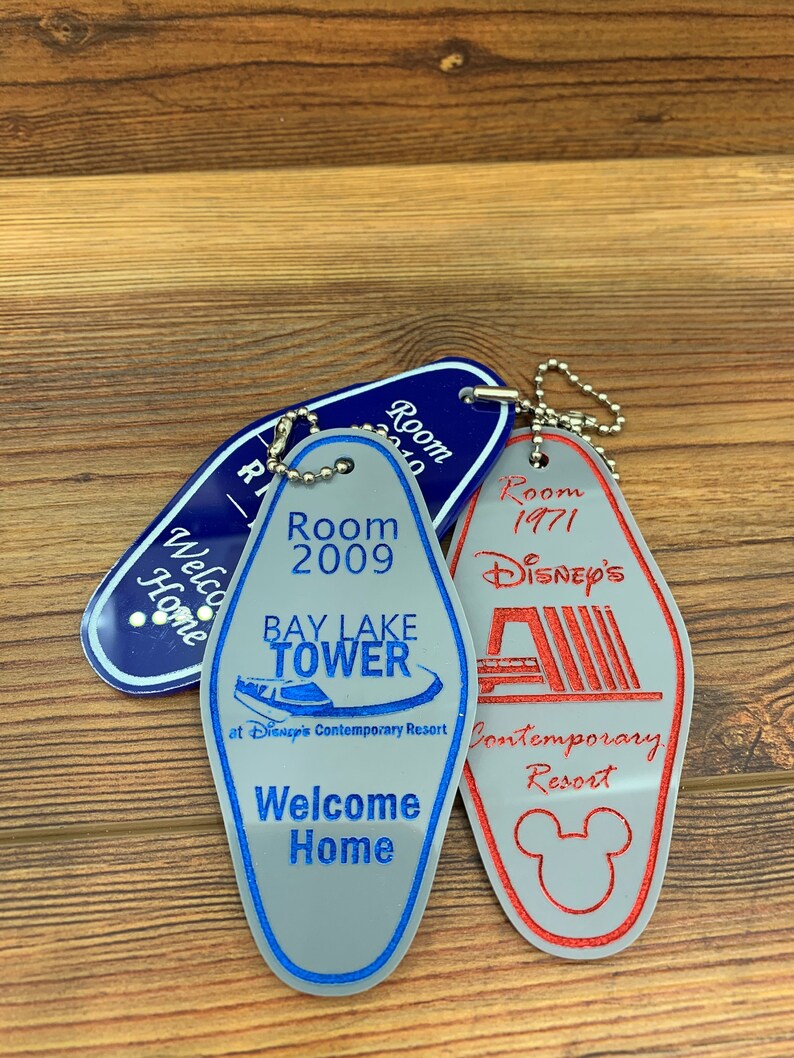 May include: Three vintage hotel keychains with blue, gray, and red colors. The keychains feature the text "Room 2010", "Room 2009 Bay Lake Tower at Disney's Contemporary Resort Welcome Home", and "Room 1971 Disney's Contemporary Resort".