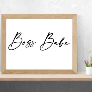 May include: A framed print with the text "Boss Babe" written in a cursive font.