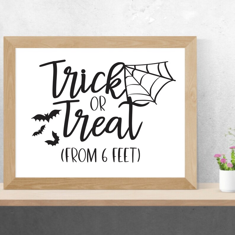 May include: Black and white sign with the text "Trick or Treat (From 6 Feet)" with a spider web and bats.