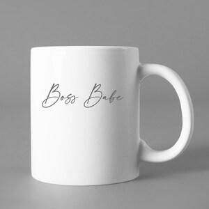 May include: White ceramic mug with the text "Boss Babe" in a cursive font.