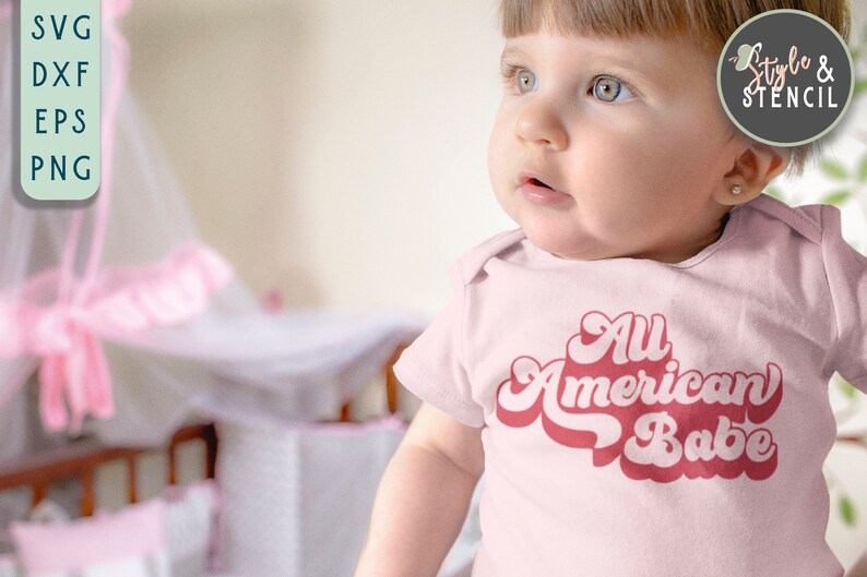 May include: A baby wearing a pink onesie with the text "All American Babe" in a retro font. The baby is looking to the right of the frame.