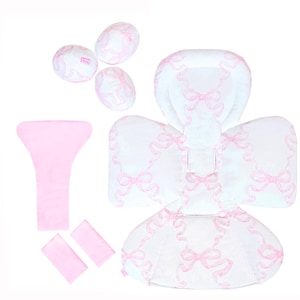 May include: A pink and white baby seat insert with a bow pattern. The insert includes a headrest, a back support, and two side supports. The insert is made of soft, breathable fabric and is machine washable.