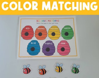 May include: A beehive matching game with colorful beehives and bees. The beehives are labeled with the colors red, orange, yellow, green, blue, purple, and pink. There are seven bees, each a different color, to match to the beehives.