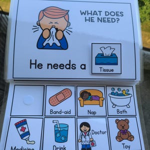 May include: A learning aid book titled "WHAT DOES HE NEED?" with illustrations of a person sneezing, a tissue box, a plaster, a nap, a bath, medicine, a drink, a doctor, and a toy.
