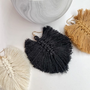 Puede incluir: Tres pares de pendientes de borla en negro, blanco y marrón. Los pendientes están hechos a mano y tienen un estilo bohemio.