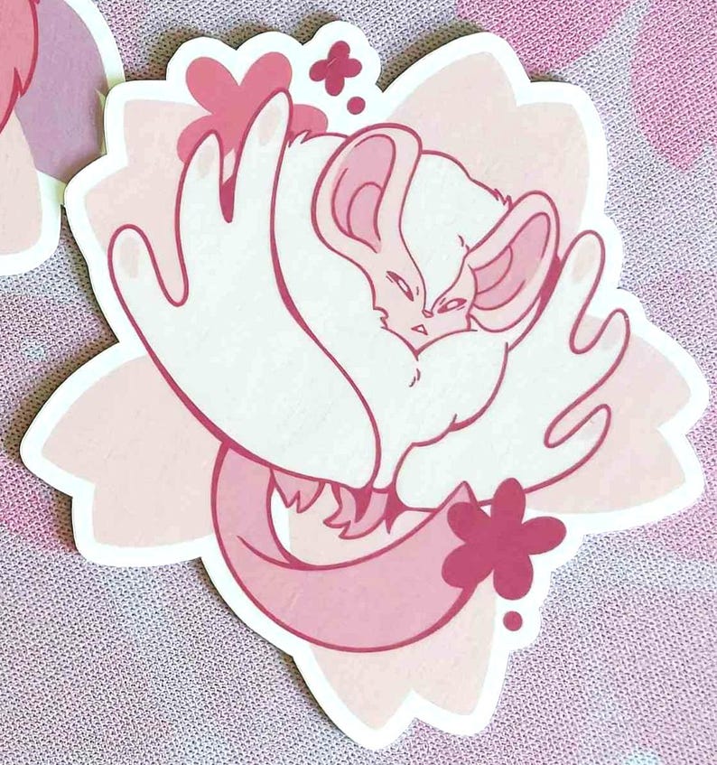 May include: A die-cut sticker featuring a stylized illustration of a white and pink creature, possibly a chinchilla or similar animal, nestled within a pink flower. The design has a soft, pastel color palette.