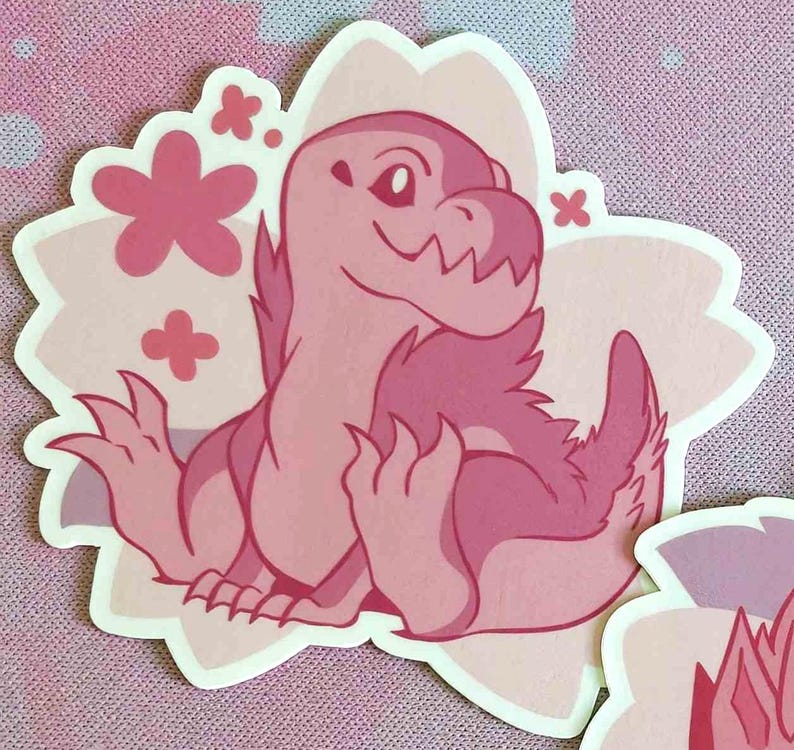 May include: A pink dinosaur sticker with a flower-shaped border. The dinosaur is sitting with its arms out and has a friendly expression. The sticker has a light pink and dark pink color scheme.
