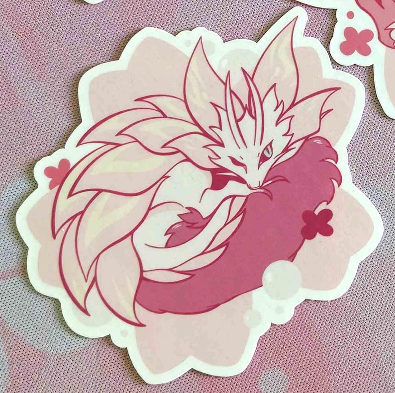 May include: A sticker featuring a stylized, curled-up fox-like creature with a floral mane and tail. The design is primarily pink and white, with a light pink floral-shaped border and small flower accents.