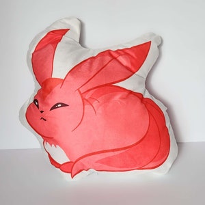 K&ouml;nnte beinhalten: Ein rotes und wei&szlig;es Pl&uuml;schkissen in Form eines Cartoon-Fuchses mit einem eingerollten Schwanz. Der Fuchs hat einen wei&szlig;en Bauch und eine wei&szlig;e Schnauze.
