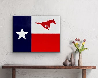 Puede incluir: Una obra de arte en lienzo con el diseño de la bandera de Texas. La obra muestra una franja vertical azul marino con una estrella blanca, una franja horizontal blanca y una franja horizontal roja. Una silueta de caballo rojo corriendo está en la franja blanca.