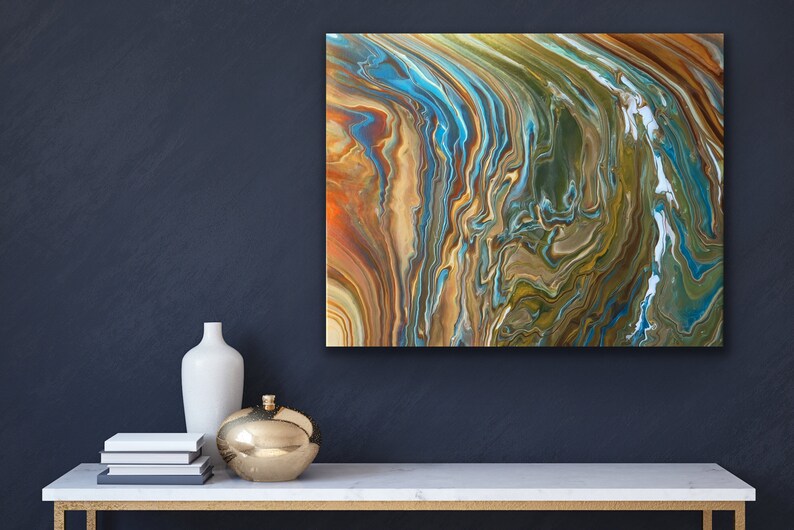 Puede incluir: Pintura abstracta con patrones en espiral en tonos de azul, verde, marr&oacute;n y dorado. La pintura est&aacute; enmarcada y colgada en una pared azul oscuro.