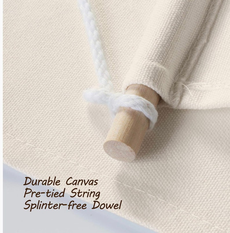 Op de afbeelding: Close-up van een wit canvas met een houten stok en een wit touw. De tekst "Durable Canvas Pre-tied String Splinter-free Dowel" is zichtbaar onderaan de afbeelding.