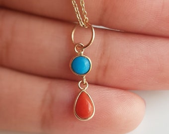 May include: A gold chain necklace with a pendant featuring a round turquoise stone and a teardrop-shaped coral stone.
