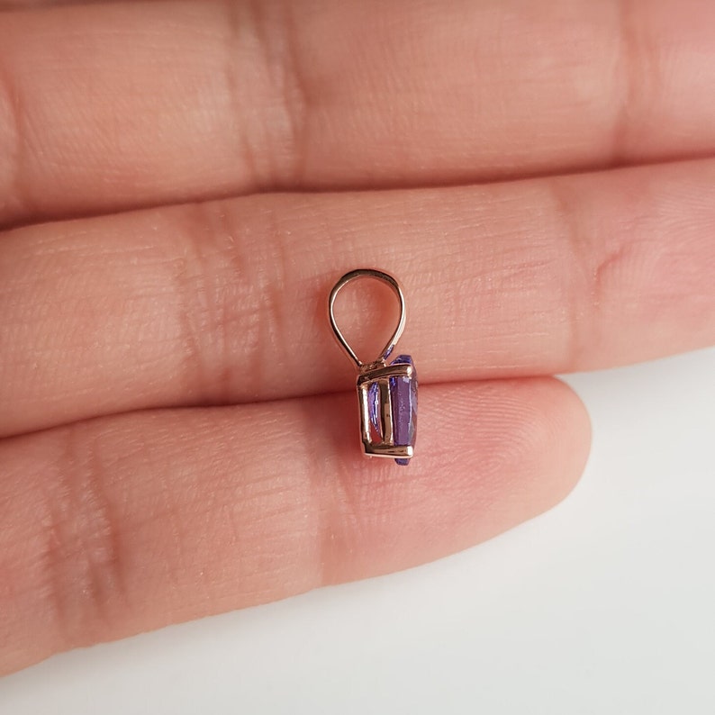 Op de afbeelding: Een hanger met een paarse edelsteen in een ros&eacute;gouden zetting. De hanger heeft een lus om aan een ketting te bevestigen.