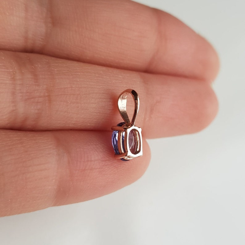 Op de afbeelding: Een hanger van ros&eacute;goud met een paarse ovale edelsteen.